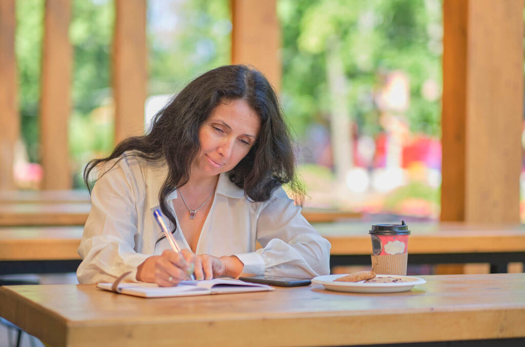 Author thoughtfully crafting a book description at a cozy workspace.