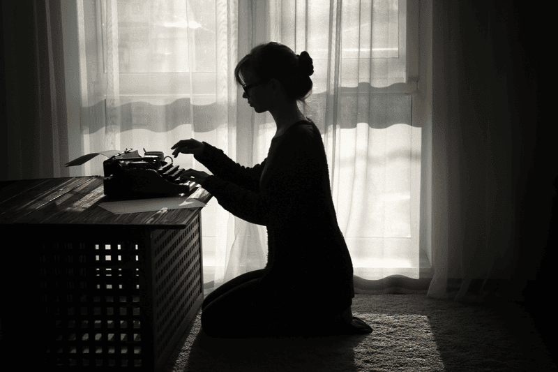 silhouette of a woman while typewriting