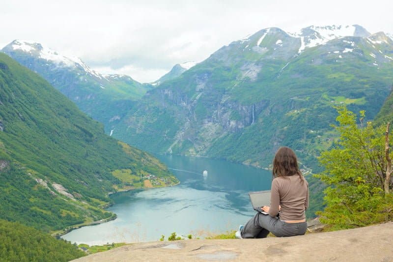 woman by a valley with a laptop