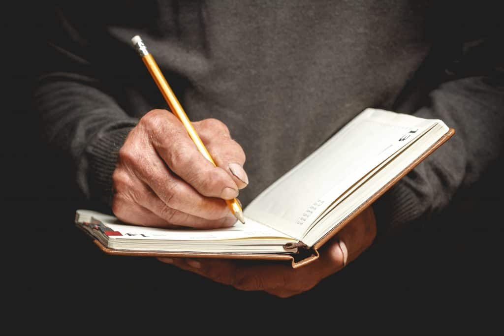 Man holding book and pencil