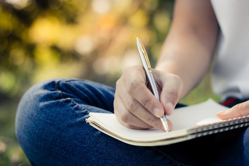 person writing on a notebook