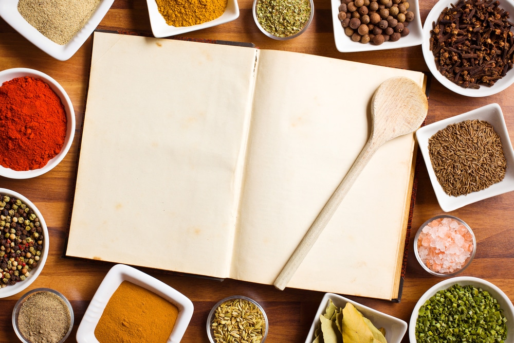 cookbook surrounded by spices