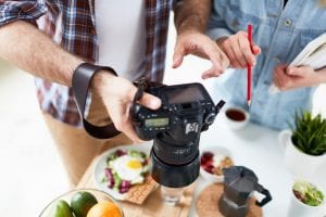 man and woman doing a photoshoot of food